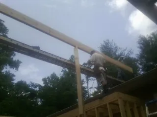 Carpenter setting a ridge beam over a new addition frame — Ice Dam Removal by Roofing Brothers in O Brien