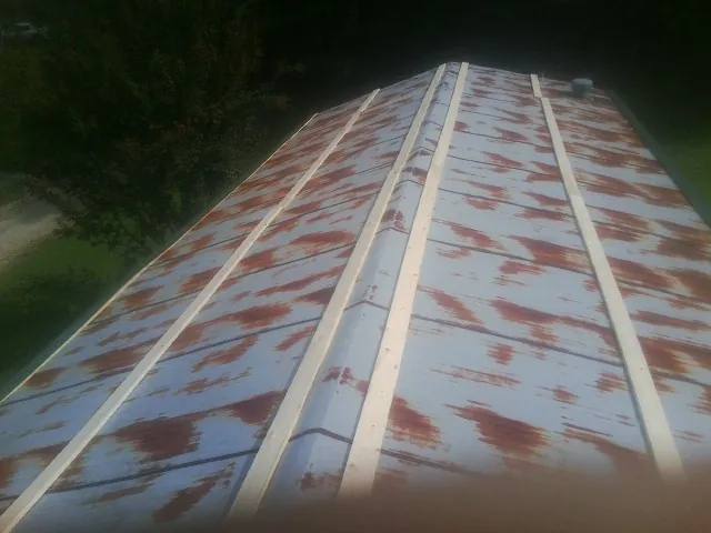 Rusted metal roof panels with new wood purlins before replacement — Storm Damage Roof Repair in O Brien by Roofing Brothers